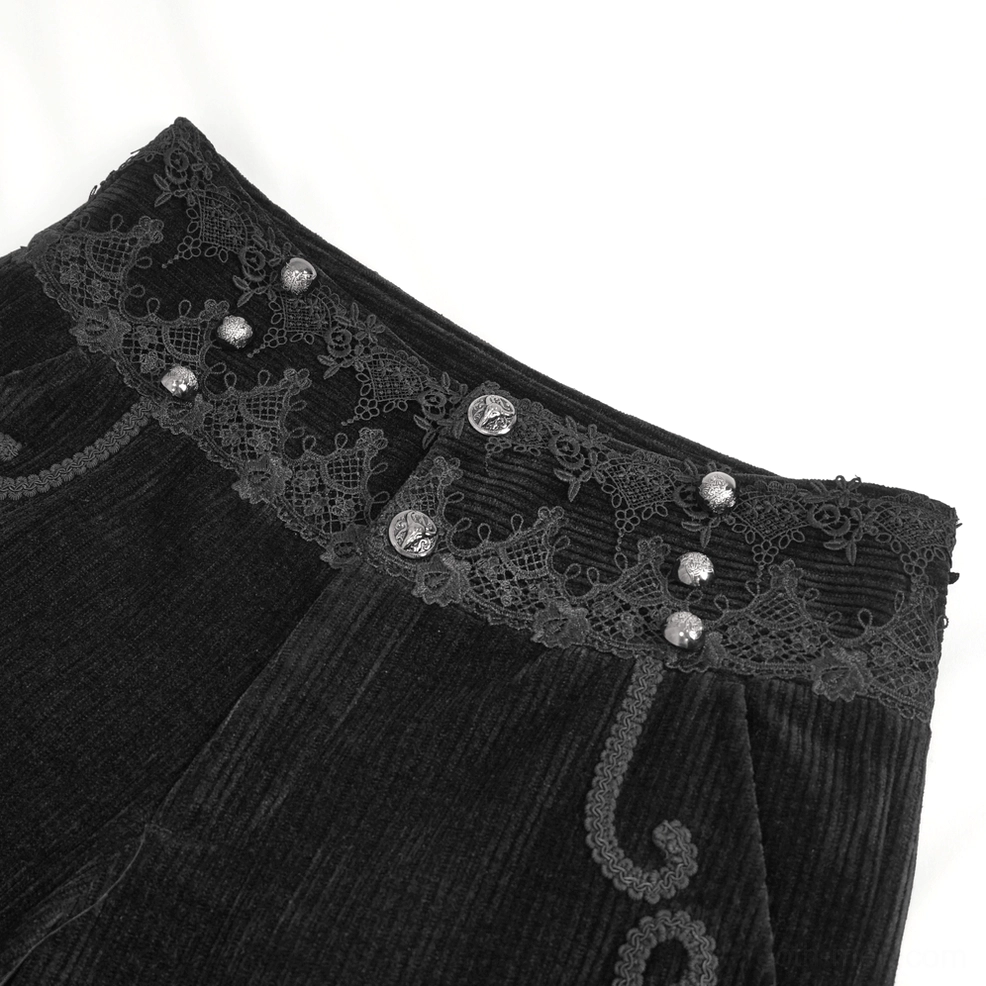 Detailed close-up of black corduroy pants waistband showing ornamental lace trim and decorative gem buttons