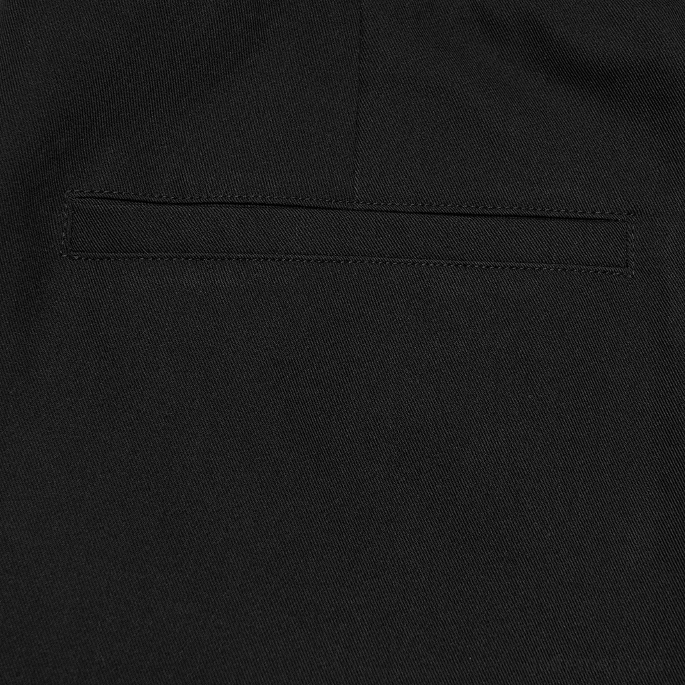 Welt pocket detail on black gothic pants showing woven fabric texture