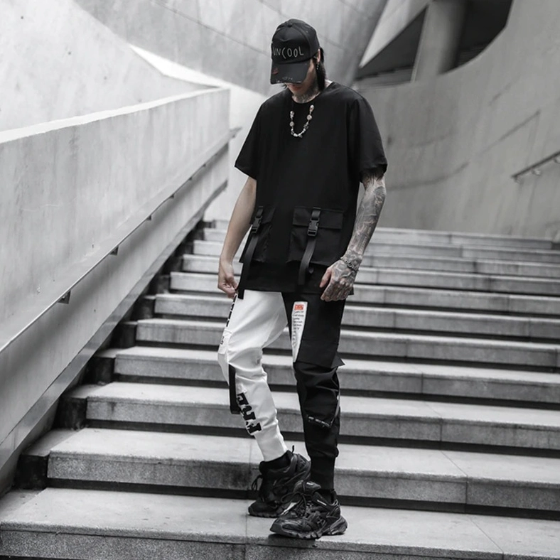 Full-body front view of male model wearing black and white gothic cargo pants with streetwear styling and ribbed cuffs