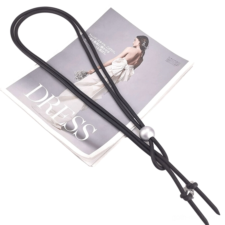 Overhead flat lay of black rubber gothic lariat necklace with pearl bead and adjustable metal knot fasteners