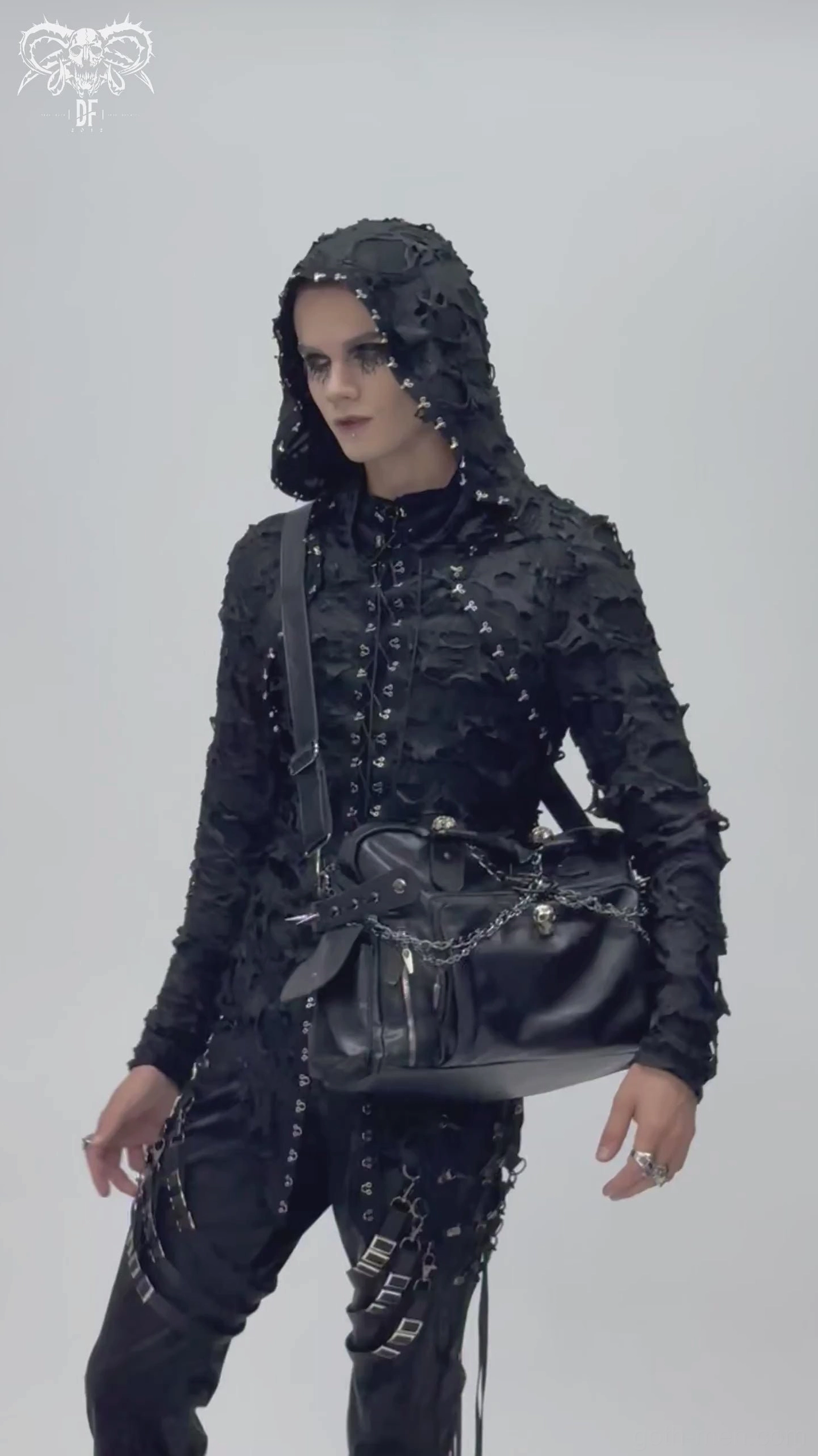 Male hooded goth model wearing black pentagram chain spike gothic tote bag as crossbody accessory with complete dark outfit