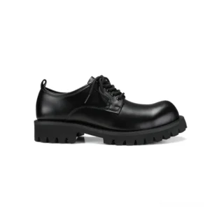 Black leather gothic boots side profile view showcasing round toe and prominent rubber tread sole