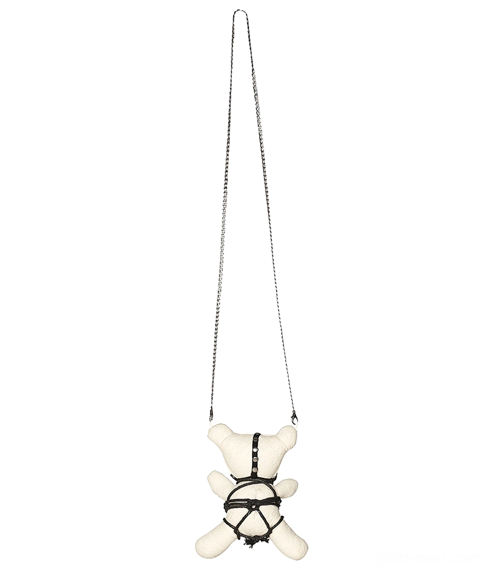Black canvas bondage harness and metal rivets on plush ornament, rear hanging perspective with chain clasp
