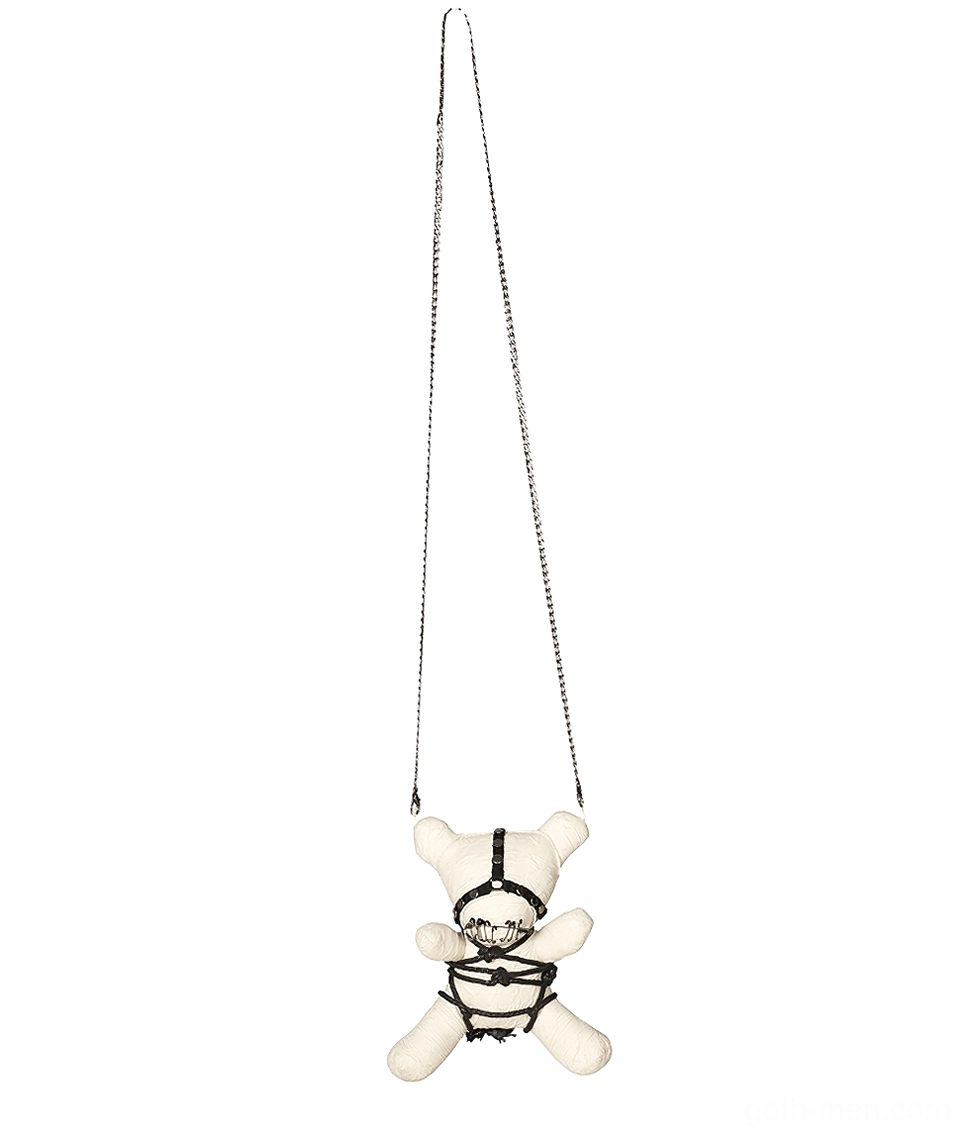 Cream-white plush ornament hanging from silver metal chain, bondage harness and safety pin mouth detail