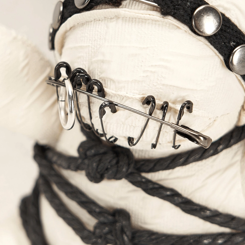Close-up of safety pin mouth and studded black canvas strap on gothic plush ornament