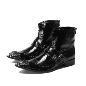 Black patent leather gothic pointed toe ankle boots with metal buckle strap and ornate metal toe cap, three-quarter front view
