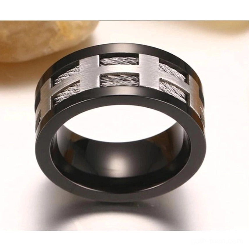 Top-down overhead view of punk cross gothic ring with brushed silver trim and black plated band on light background