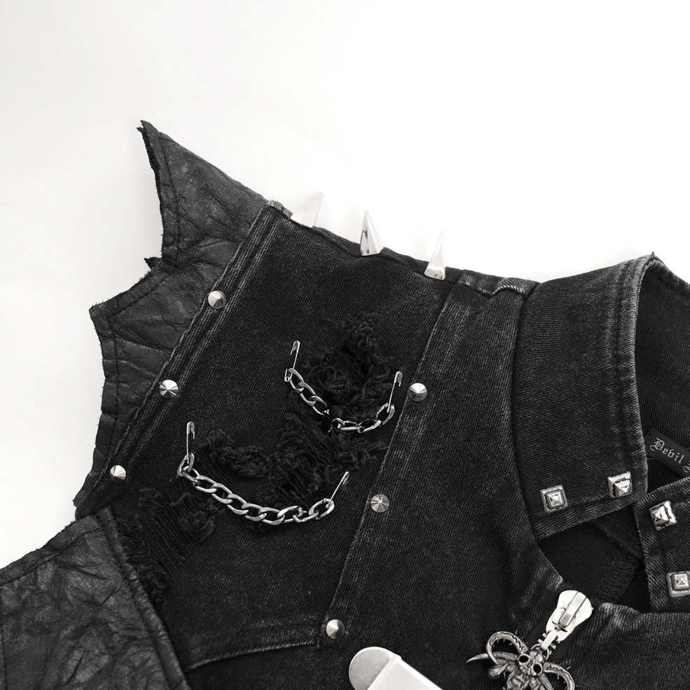 Close-up detail shot of gothic punk vest metalwork including studs chains and distressed frayed black denim