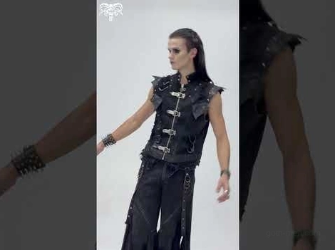 Side angle of black gothic punk denim vest with frayed hem, metal buckles and punk accessories styling