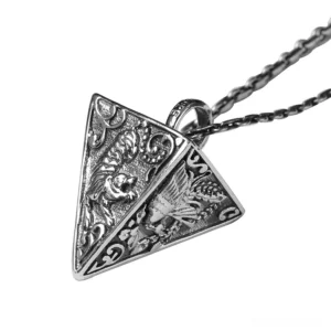 Oxidized silver pyramid pendant with hand-embossed animal and dragon motifs, detailed side overhead view showcasing intricate relief carving