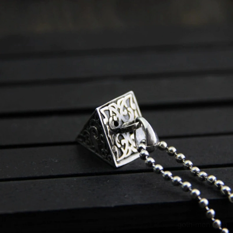 Front overhead view of sterling silver pyramid pendant with animal and floral embossments and dangling beaded necklace chain