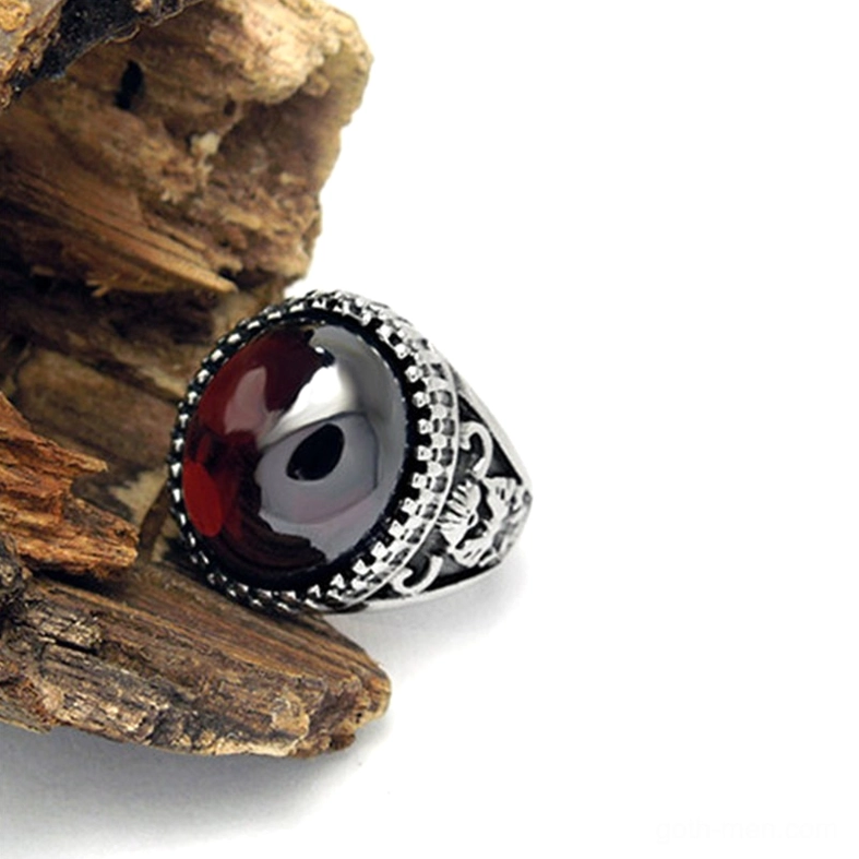 Deep red gothic ring left-side close-up, smooth gemstone, vintage-inspired engraved metal band