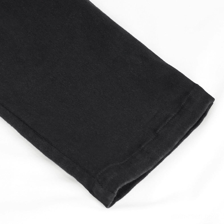 Close-up view of gothic ripped pants hem showing solid black denim fabric and neat folded edge
