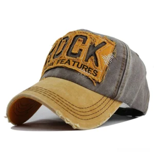 Faded yellow brim distressed denim cap front three-quarter view with ROCK embroidery patch and worn texture
