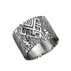 Ancient rune stainless steel gothic ring with embossed Viking symbols and brushed silver finish, oblique side view showing wood grain texture detail