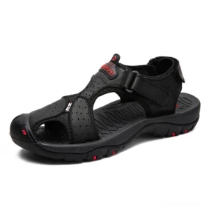 Black perforated leather gothic sandals with hook-and-loop ankle strap and red outsole accents, side three-quarter view