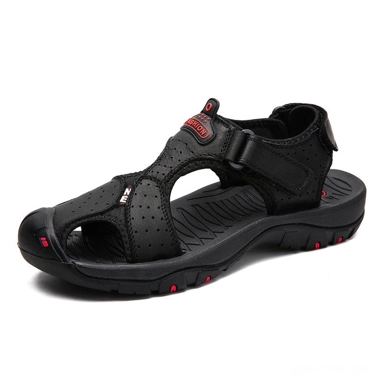 Black perforated leather gothic sandals with hook-and-loop ankle strap and red outsole accents, side three-quarter view