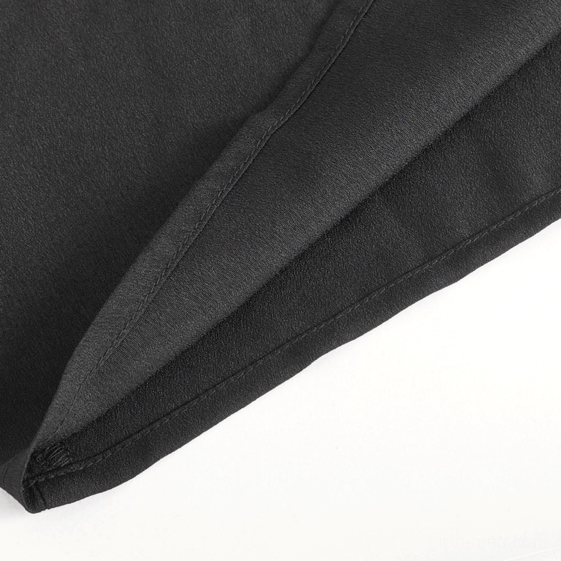 Black gothic ruffle shirt body fabric close-up showing smooth matte polyester weave and neat seam stitching