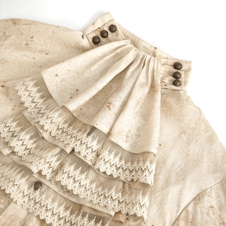 Close-up detail of layered ruffled lace necktie with metal collar buttons showing gothic aesthetic and distressed stained fabric