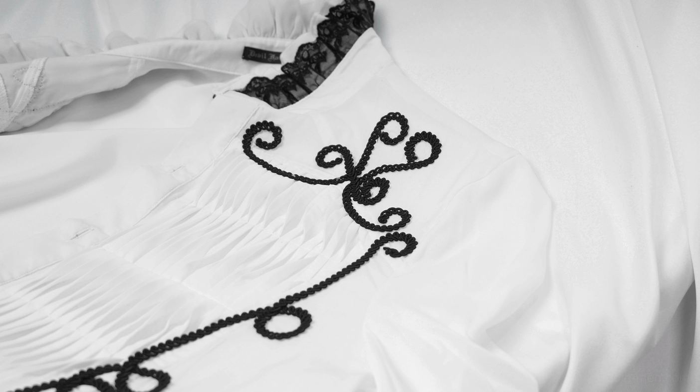 Top-down close-up view of white gothic shirt's black lace stand collar with pleated front and baroque embroidery