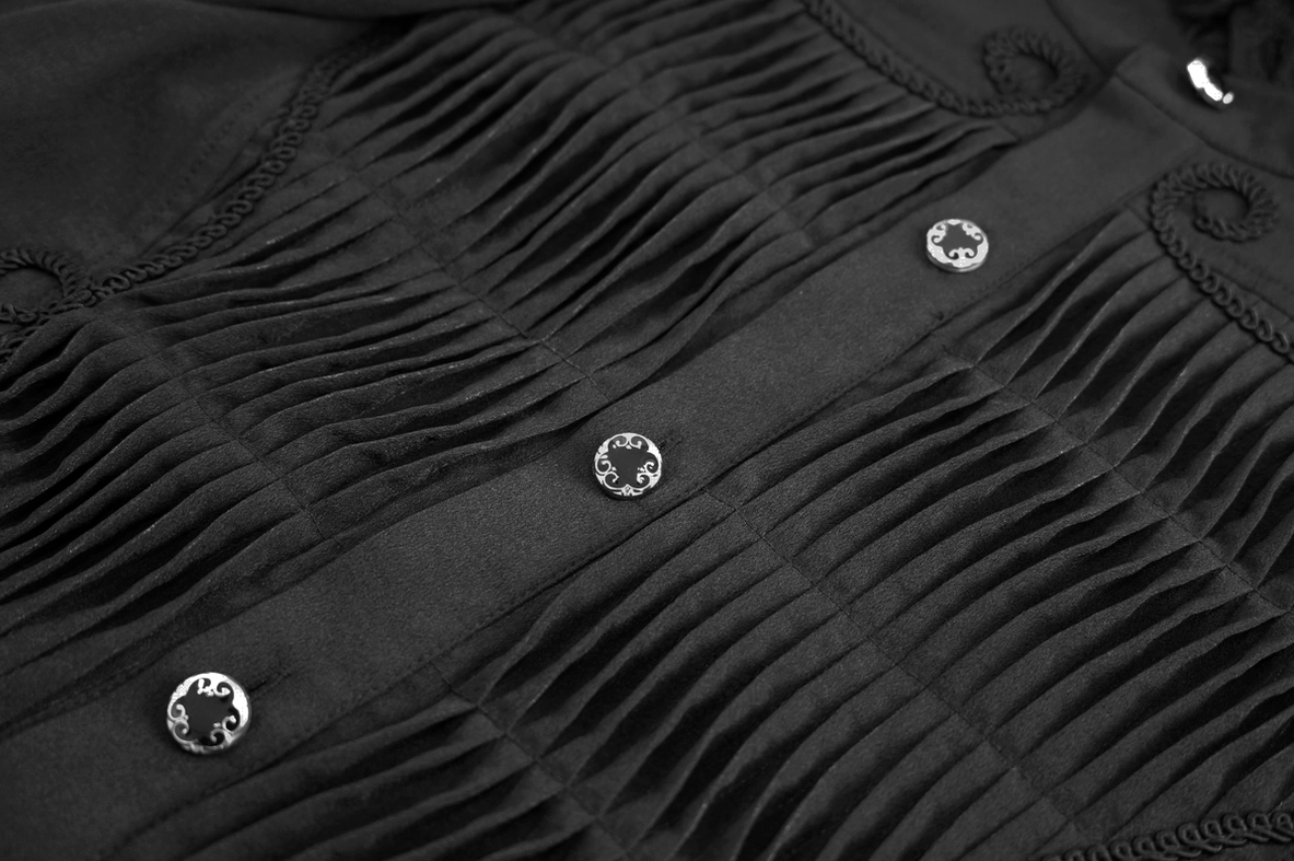 Close-up view of black gothic shirt front pleated panel with vintage metal buttons and embroidered trim