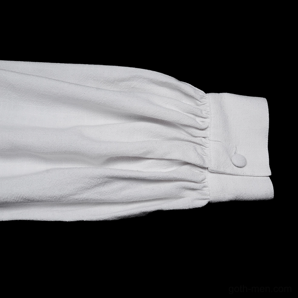 Close-up view of gathered puff cuff with single button fastener on white gothic embroidered shirt