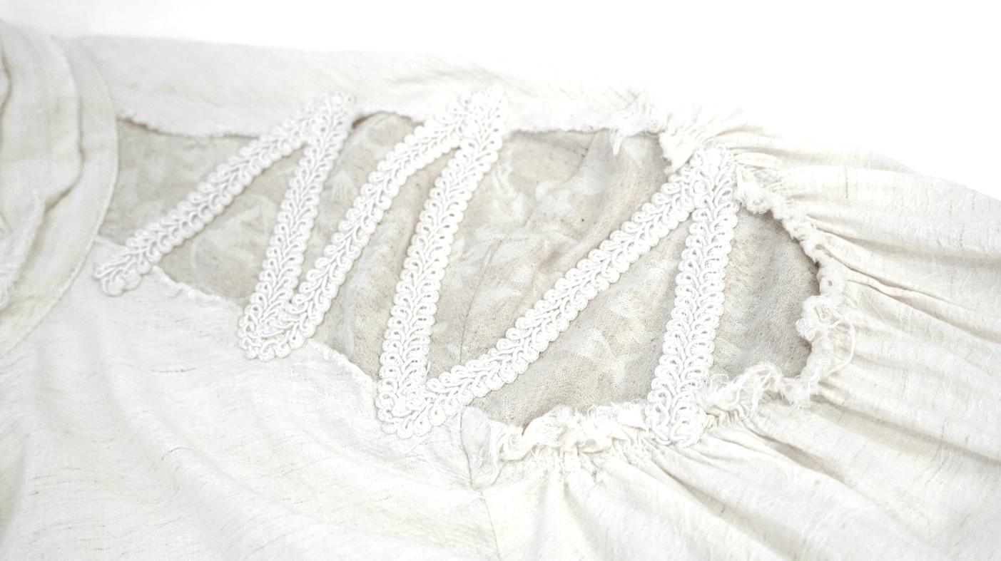 Shoulder panel detail showing lace trim, mesh insert, and ruched fabric construction