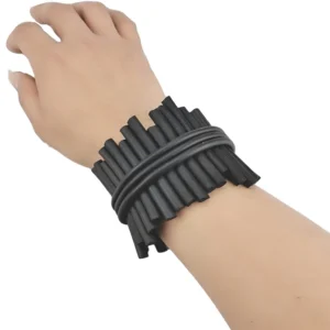 Black gothic wide silicone bangles worn on wrist showing bundled cylindrical rod structure