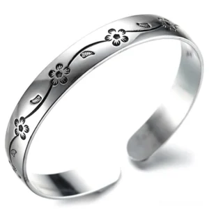 Dark floral silver gothic bangle bracelet with oxidized vine engraving, oblique side view showing vintage patina effect