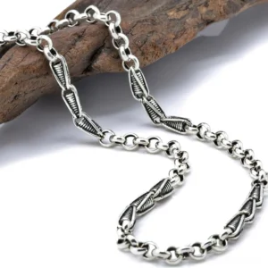 Vintage twisted sterling silver link chain necklace with antiqued patina and fishhook clasp, displayed on wooden surface with gothic styling