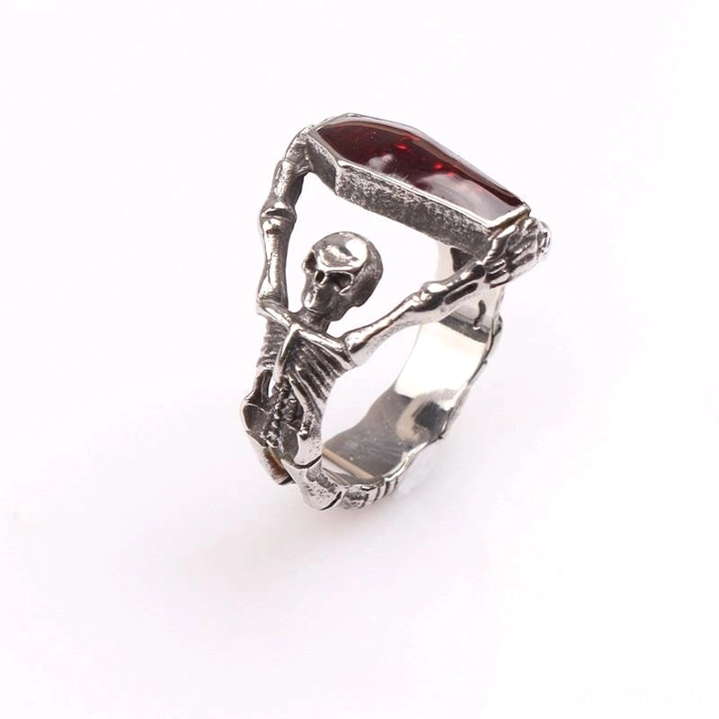 Low side three-quarter view of gothic skeleton coffin ring - skeleton holding red coffin gem with antique silver metal construction