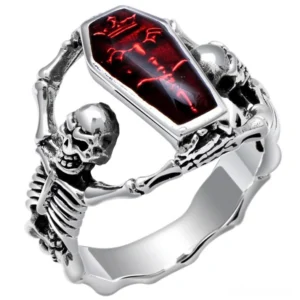 Gothic skeleton coffin ring silver with red stone - front three-quarter view showing detailed skeleton holding red cubic zirconia gem