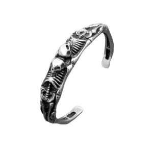 Memento mori skeleton cuff bracelet with dual skull and ribcage carvings in silver stainless steel – gothic statement jewelry, left front view
