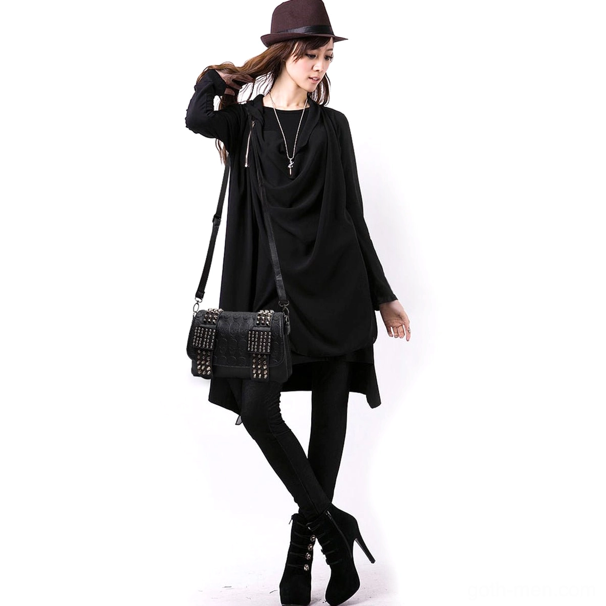 Female model wearing black skull rivet studded crossbody messenger bag full body side view alternative fashion styling on white background