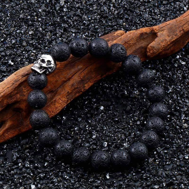 Adjustable gothic skull bracelet with stainless steel accent on wooden and gravel background
