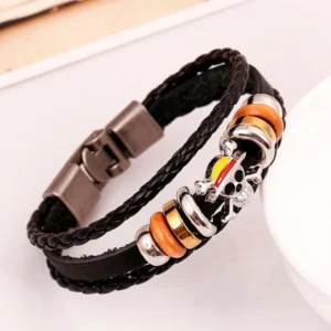 Layered gothic skull bracelet featuring colored enamel skull charm and warm metallic spacer beads on braided leather - angled tabletop product photography