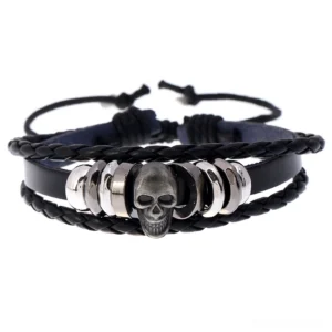 Black leather multi-layer gothic skull bracelet flat lay featuring silver-toned skull charm and handwoven braided leather design on white background