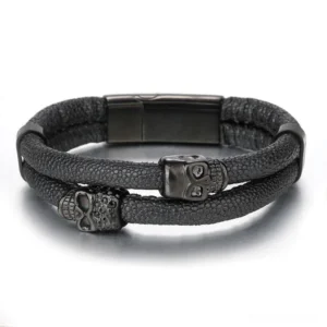 Top-down view of gothic men's leather skull bracelet showing dual skull ornaments and invisible magnetic clasp in all-black tone