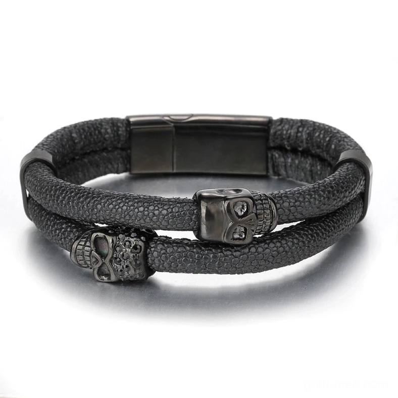 Top-down view of gothic men's leather skull bracelet showing dual skull ornaments and invisible magnetic clasp in all-black tone