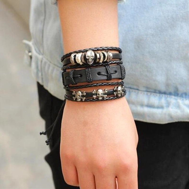 Worn black gothic leather bracelet with skull charm on wrist casual styling