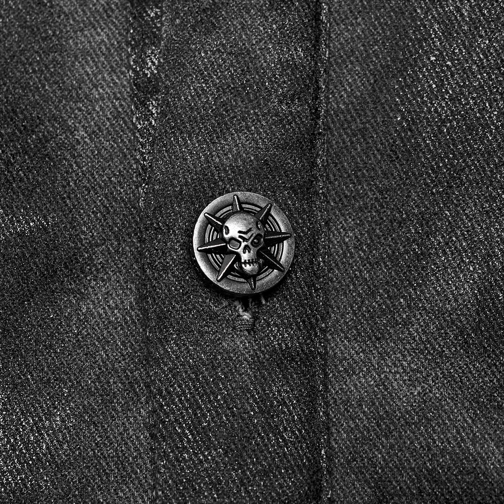 Macro close-up of embossed skull metal button on gothic sleeveless tank, detail shot of button craftsmanship