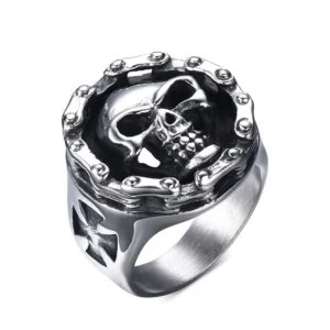 Gothic skull cross stainless steel biker ring with studded frame, top-front view showing detailed bone relief and cross cutout design