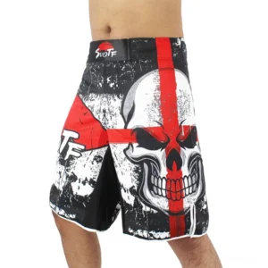 Front left view of black gothic skull cross training shorts with red multi-color print and distressed texture worn on male model