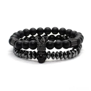 Black gothic dual-layer charm bracelet set with matte stone beads, skull and crown charms, flat lay view
