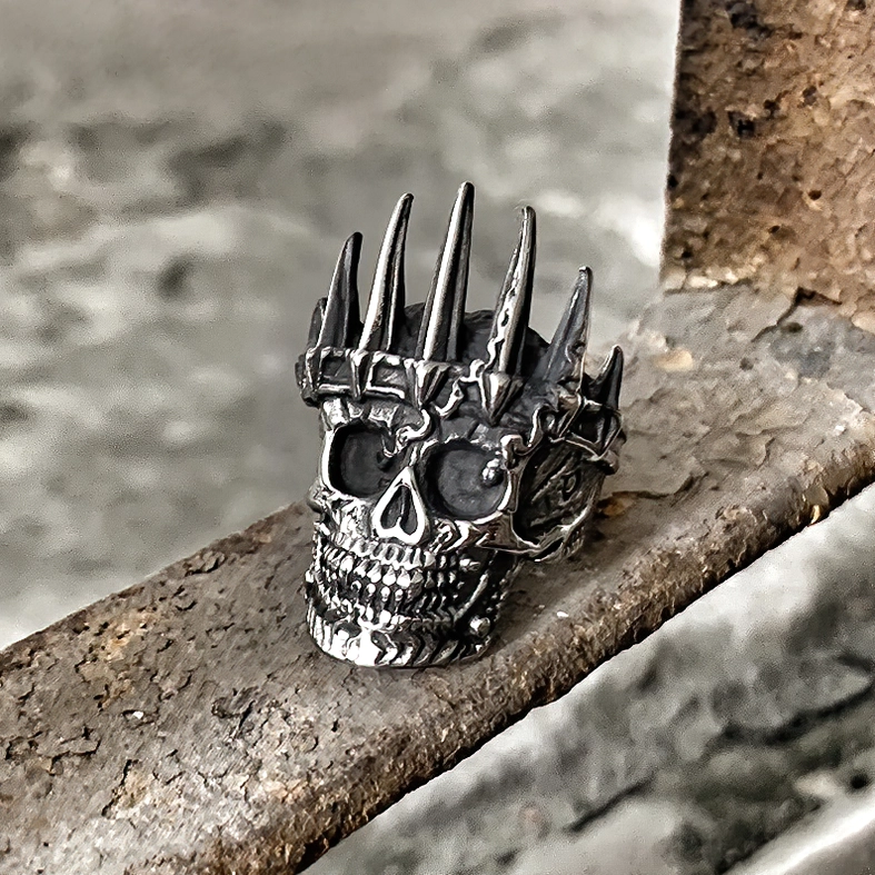 Dark aged silver skull crown ring rustic styled photography on metal and concrete background gothic aesthetic jewelry
