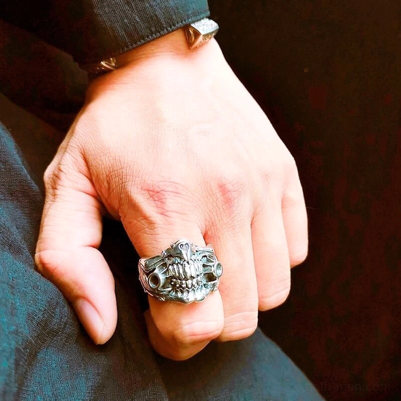 Side hand view of skull mask ring showing detailed gothic design worn with denim for everyday alternative styling