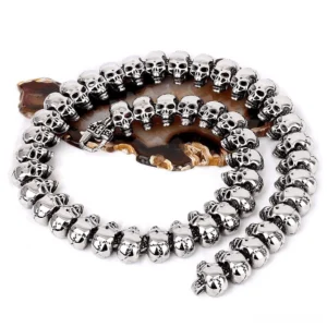 Vintage biker skull necklace flat lay top view showing interconnected 316L stainless steel skull link chain on agate stone