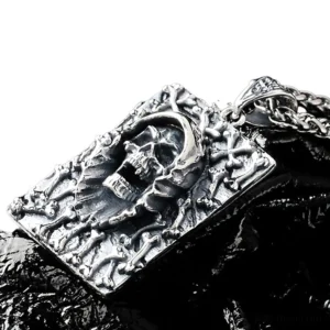 3D embossed gothic memento mori skull pendant, oxidized silver metal, angled top-down detail shot