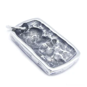 Back side view of weathered ghost skull dog tag pendant showing textured uneven surface finish in silver tone