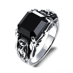 Black zircon gothic skull ring with 316L stainless steel band, three-quarter front view showing carved skull motifs and square cut gemstone